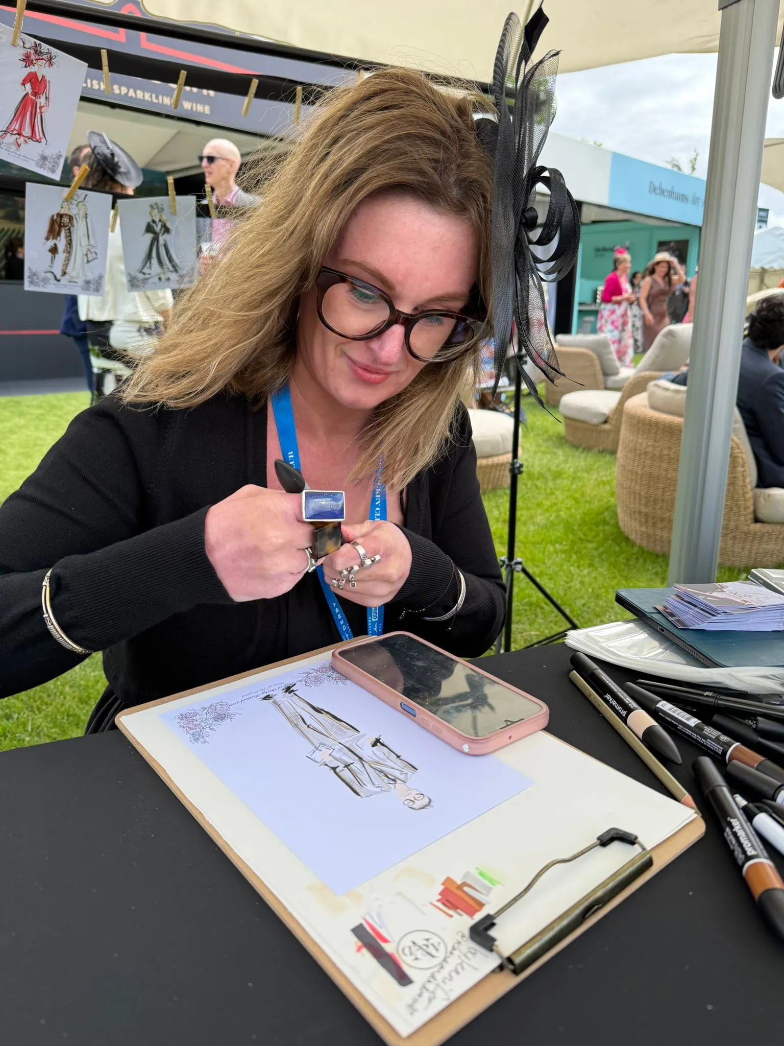 Jennifer the illustrator sketching fashion designs on a clipboard outdoors.