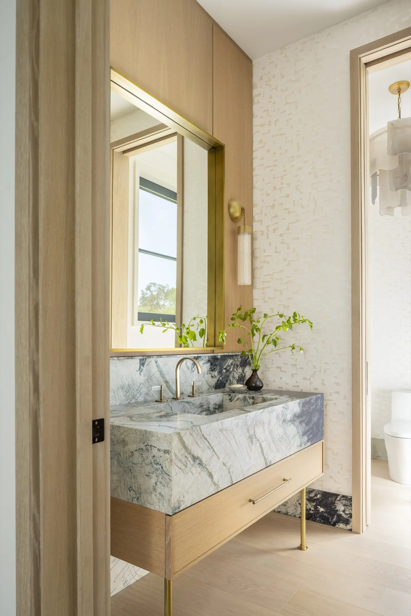 Primary bathroom with floating marble vanity and brass fixtures