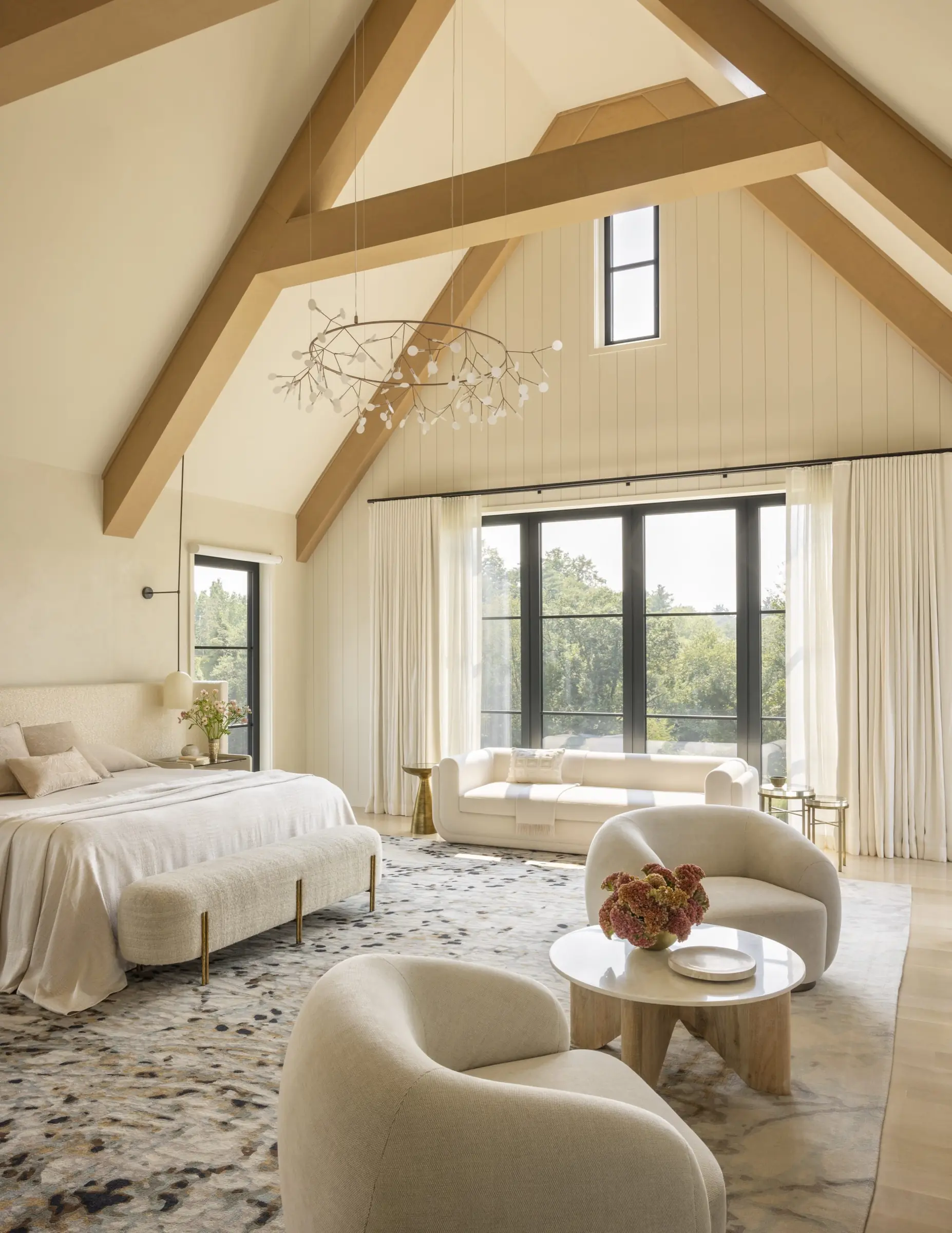 Primary bedroom with vaulted wood beam ceiling and matching seating areas