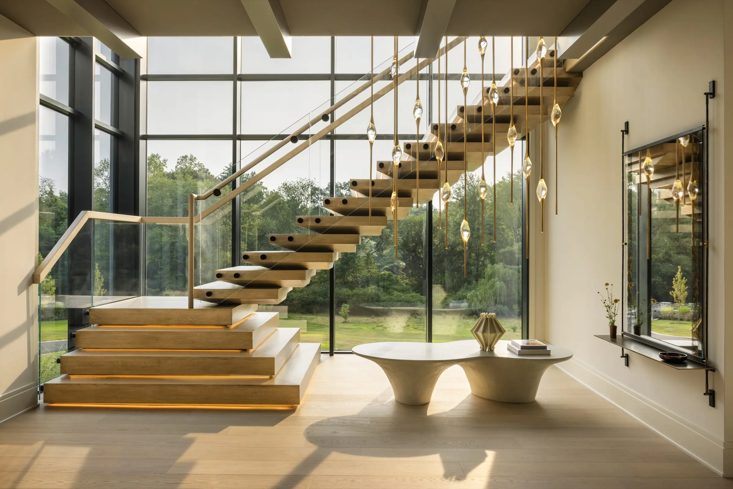 Staircase with glass railing and custom pendant lighting installation
