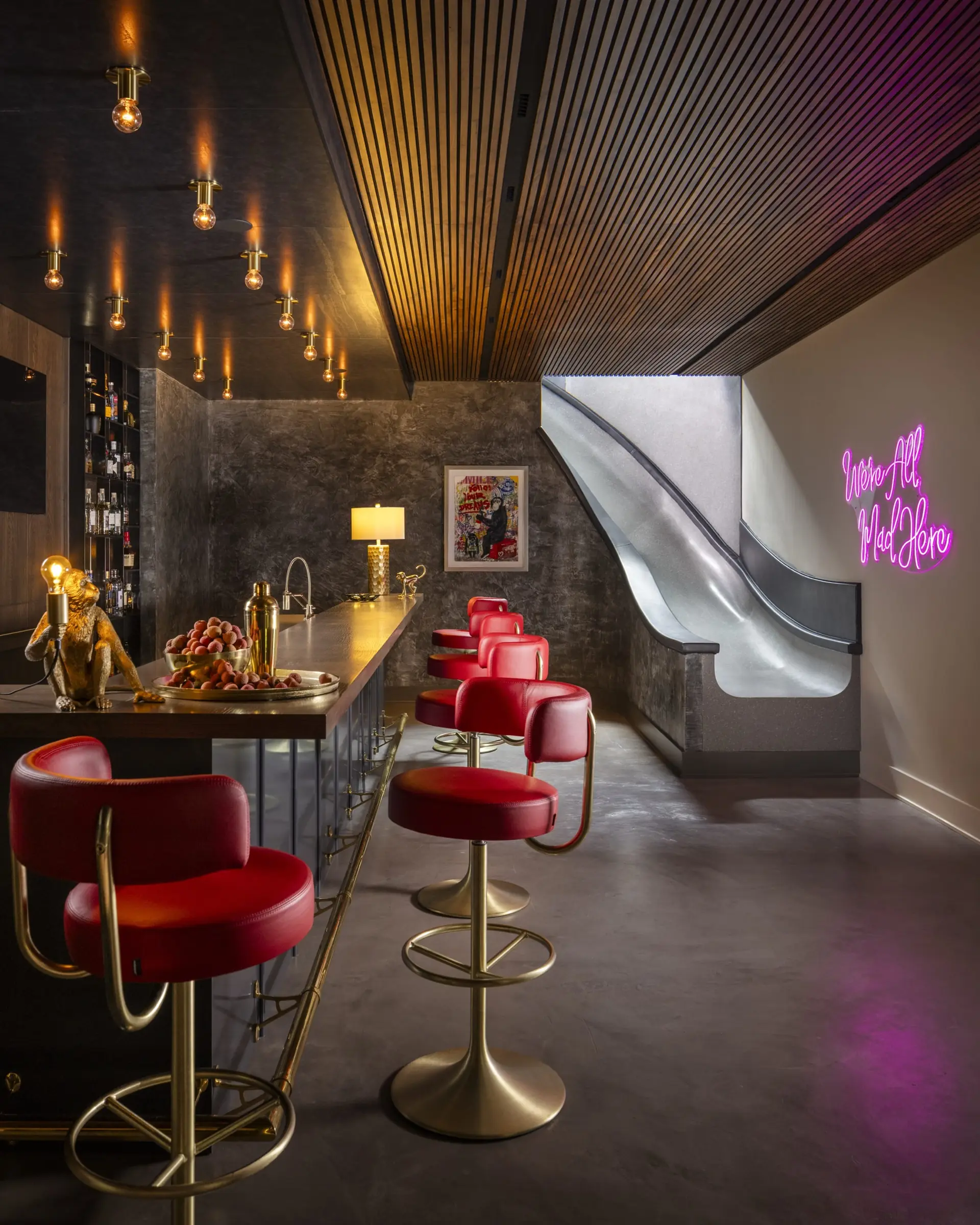 Speakeasy bar with red leather barstools and neon signage, bespoke interior design in NYC