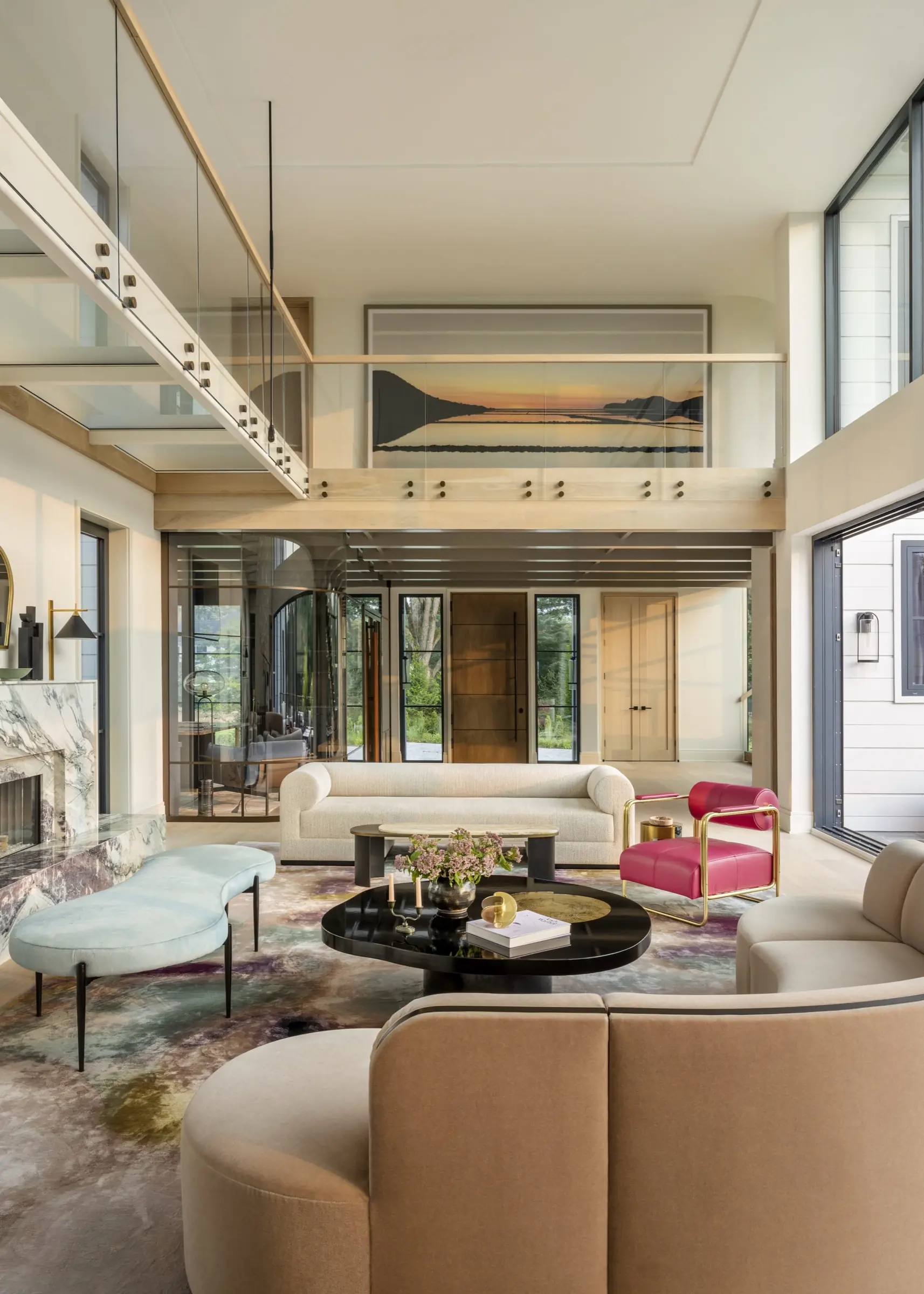 Double-height great room with curved sofas and large-scale landscape artwork