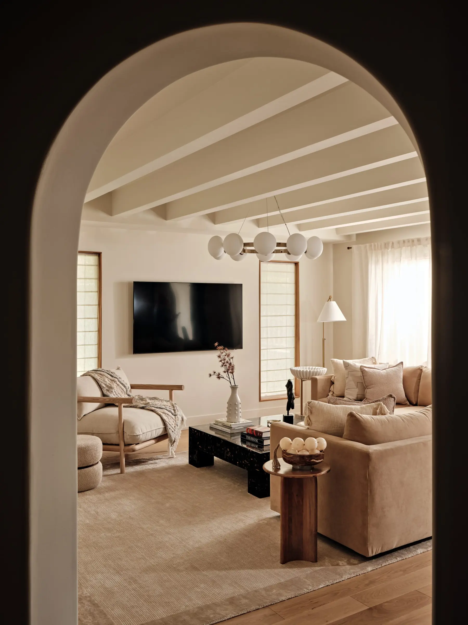 Living room viewed through a curved plaster archway, residential interior design in Miami