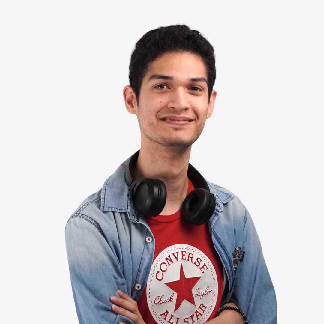 Portrait of a young man with short black hair wearing a white shirt against a beige background.
