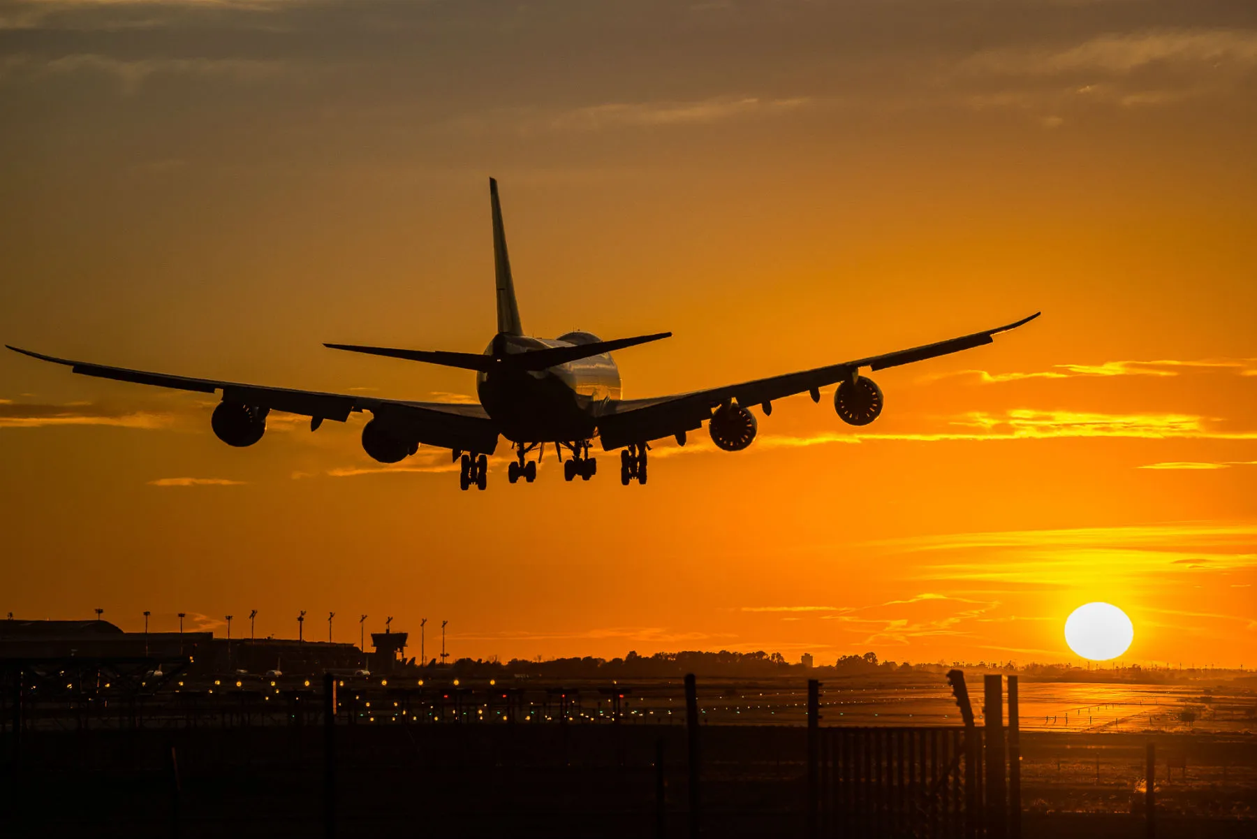 Un avion à l’atterrissage au coucher du soleil