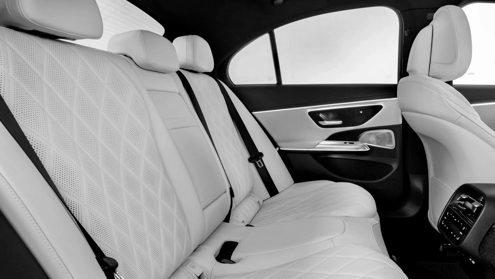 Rear cabin of a luxury sedan, seat belt fastened, natural light