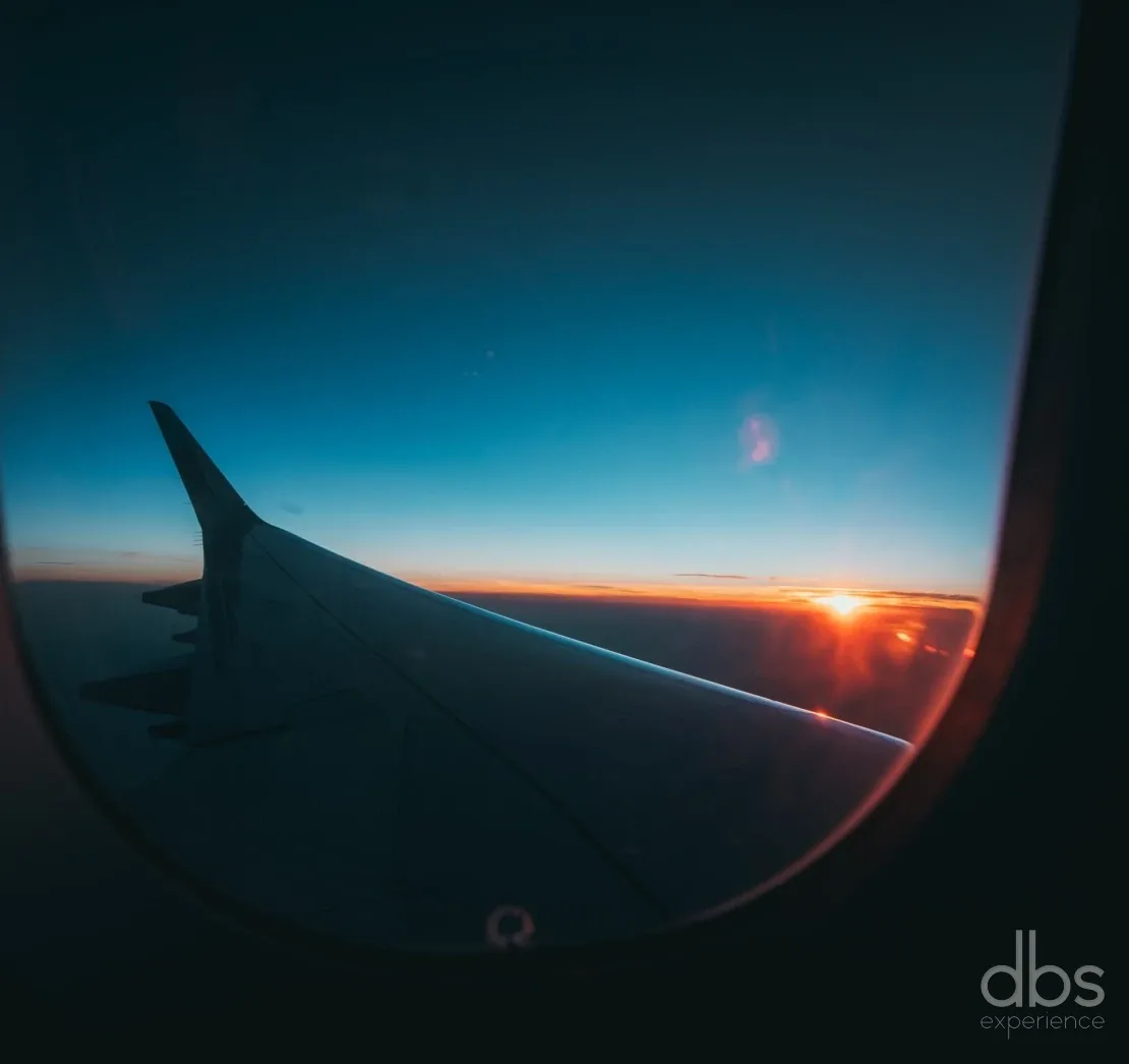 Aircraft wing seen through a cabin window at sunset