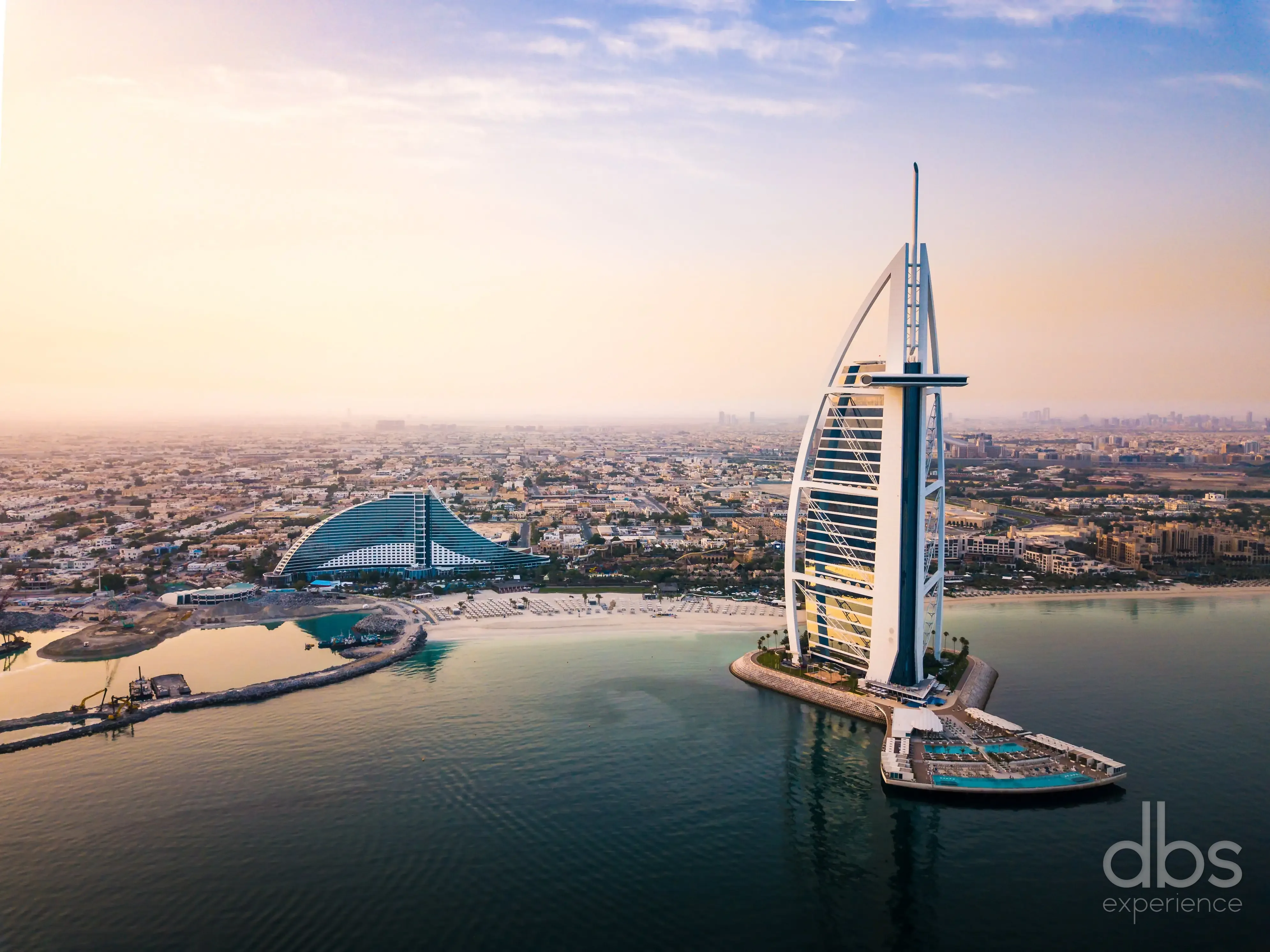 Burj Al Arab and the wave-shaped Jumeirah Beach Hotel on the Dubai coast at dusk