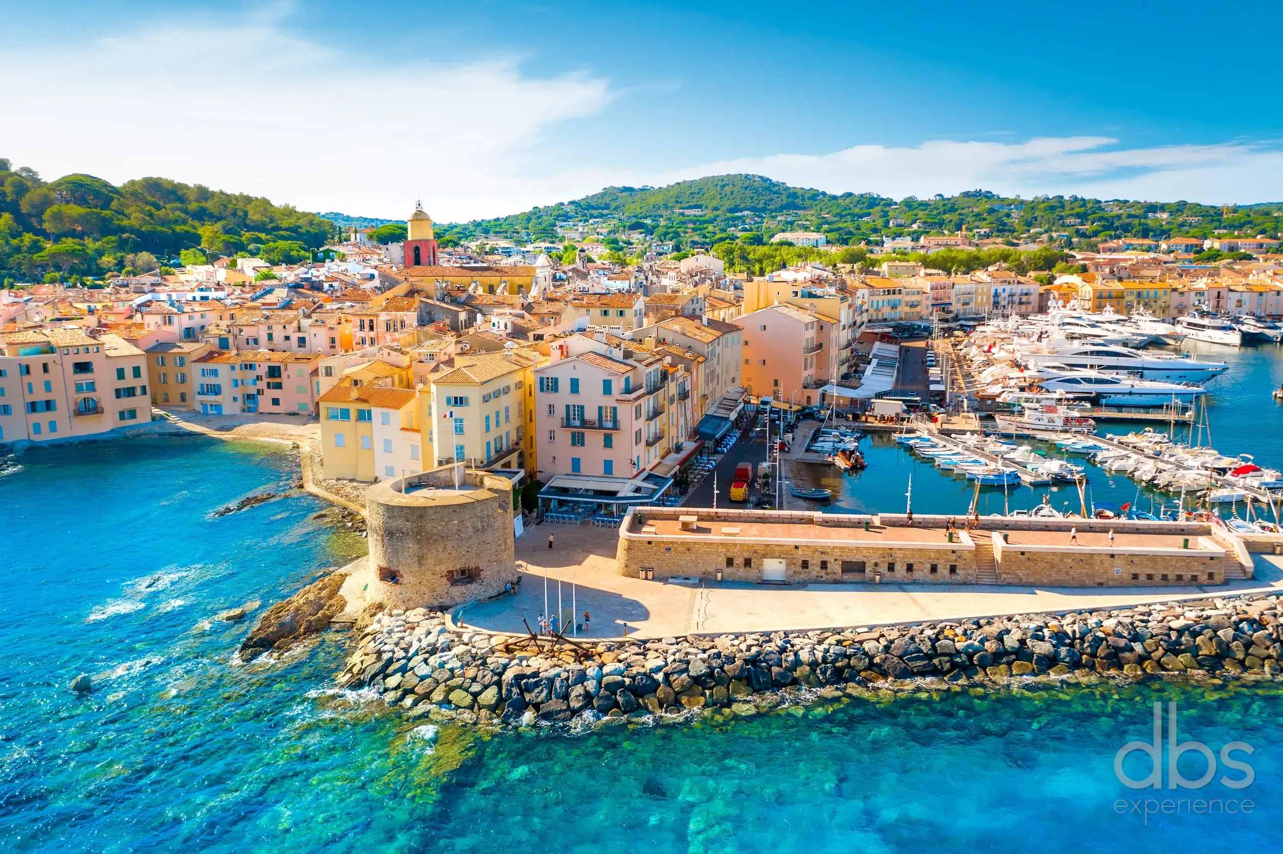 Aerial view of the Saint-Tropez harbour, old town and moored yachts on a sunny day