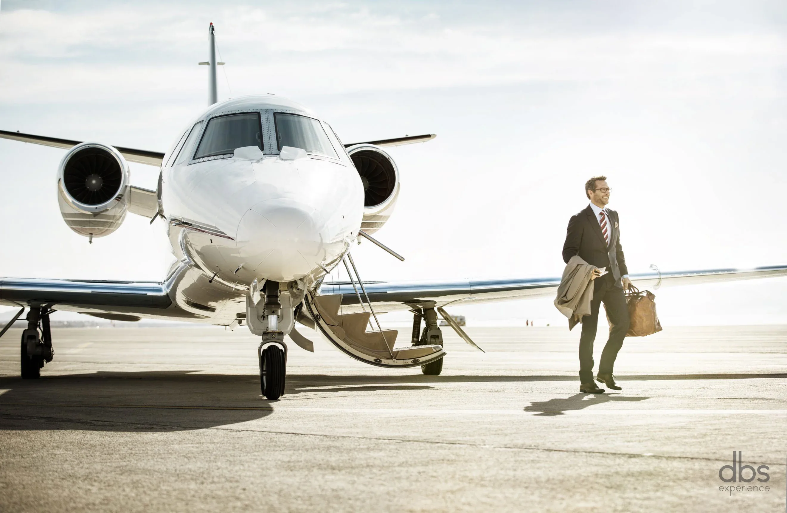 An executive stepping off a private jet onto the apron before a chauffeured transfer in Paris