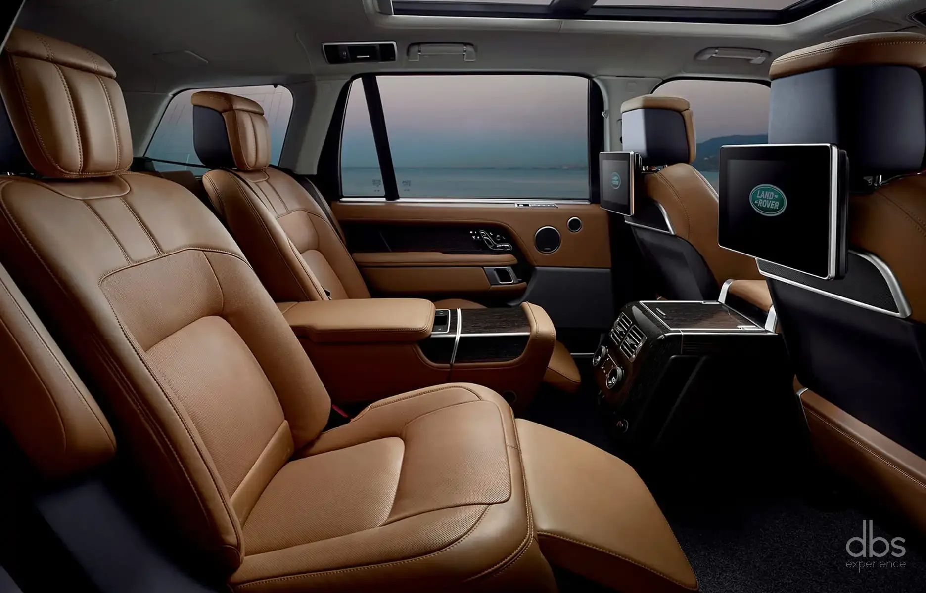 Rear cabin of a Range Rover Autobiography with cognac leather and twin rear screens, a DBS EXPERIENCE chauffeur car in Paris