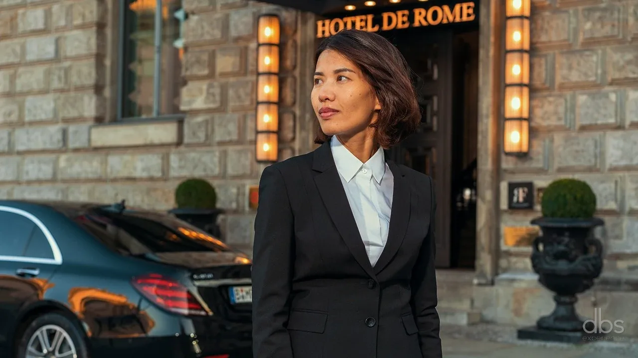 Woman chauffeur of DBS EXPERIENCE in front of a Paris hotel