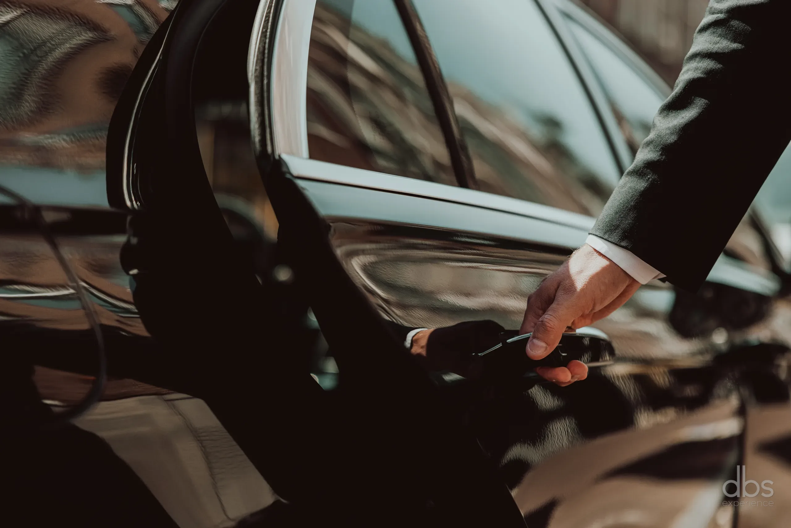 A chauffeur opening the rear door of a car