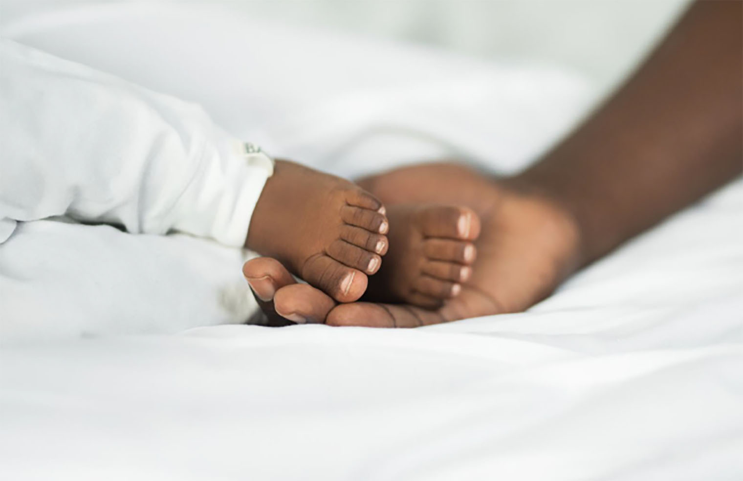 A baby's feet being held in an adult's hand