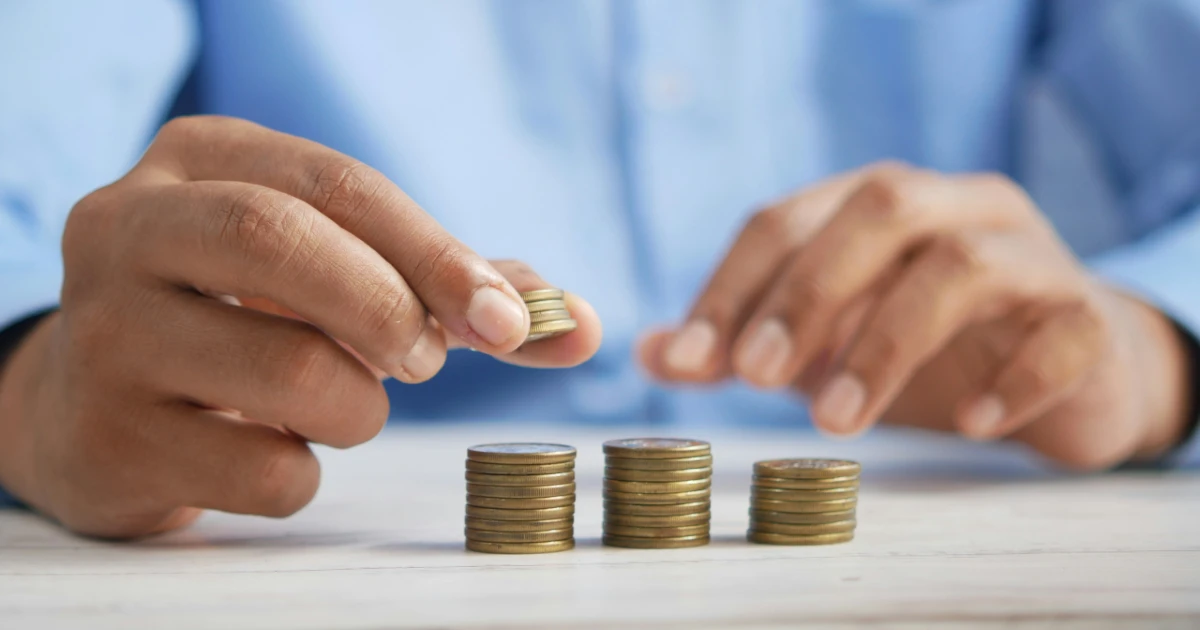A man stacks coins to represent tax savings