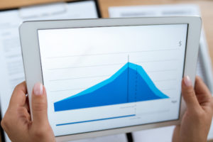 Hands Of Young Contemporary Real Estate Agent Or Financial Advisor Holding Tablet With Rate Change Graph. Tips For New Landlords