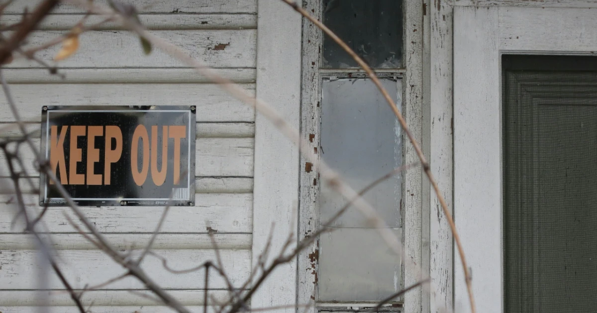 A keep out sign for squatters on a rental property