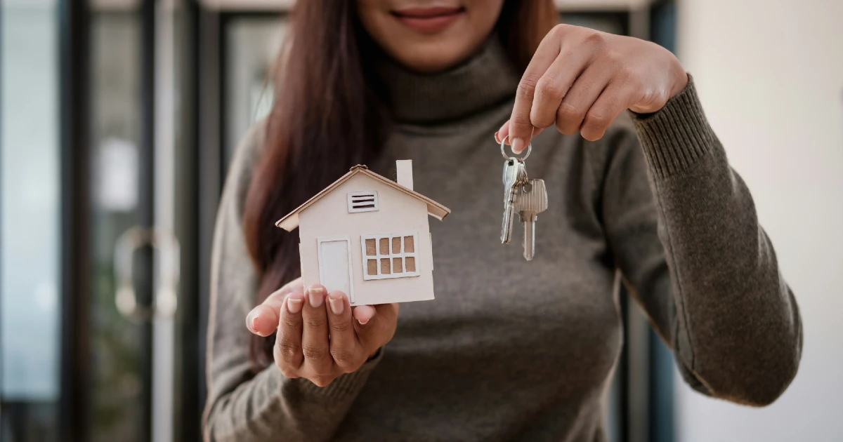 A woman holds keys to a rental property house