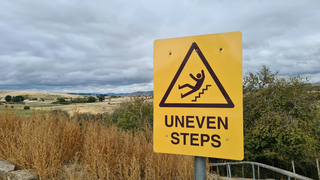A sign that says 'uneven steps' at a rental property