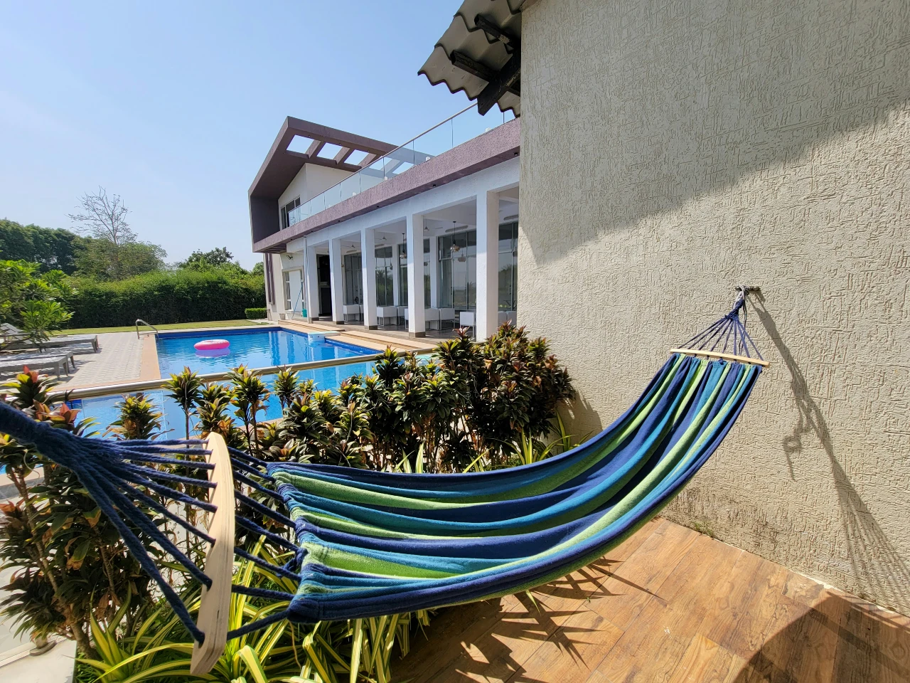 An outdoor hammock by the pool at a short term rental property