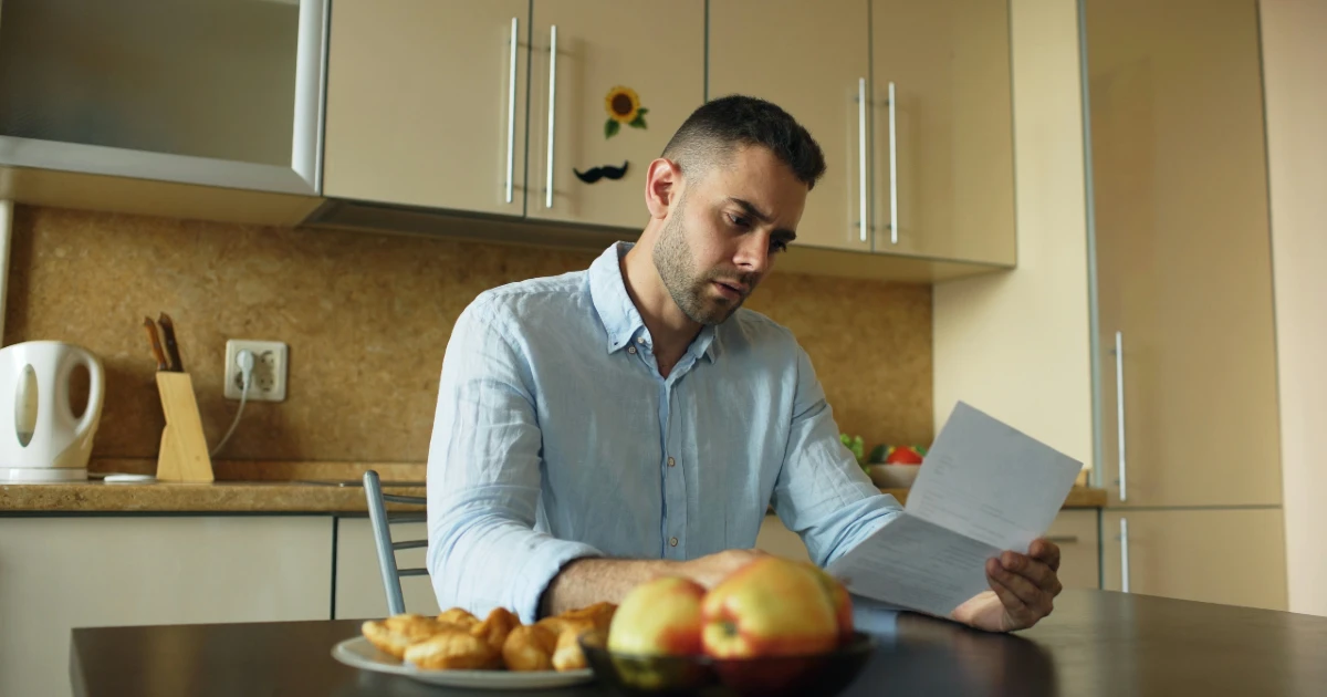 A man reads a letter saying his insurance claim was denied