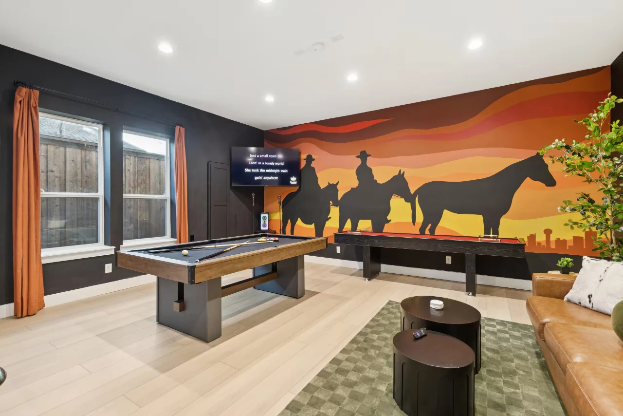 Game room at the Dallas Airbnb with a pool table, shuffleboard, and a mural of cowboys and the Dallas skyline