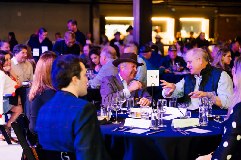 Guests laughing over wine at a set table during a private dinner at Tannahill's