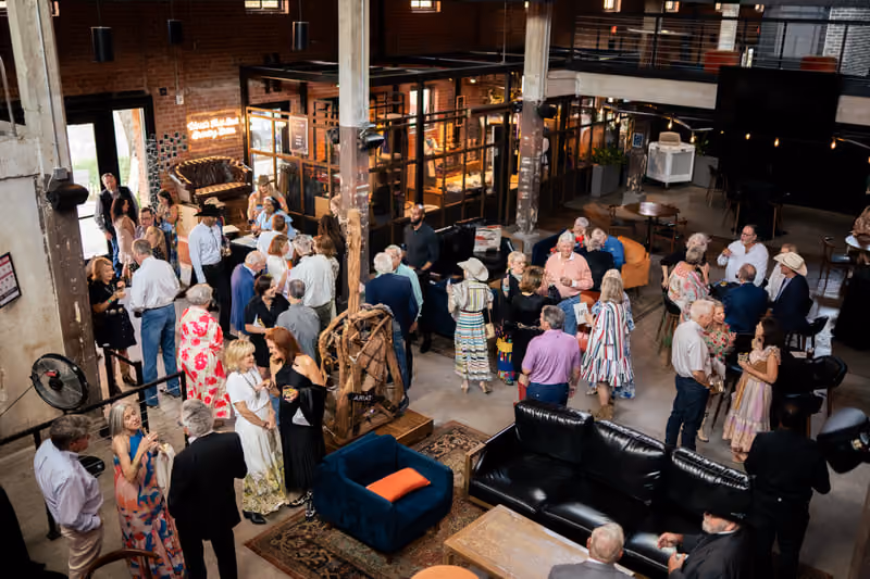 Happy hour guests mingling with drinks among the leather sofas in the lounge