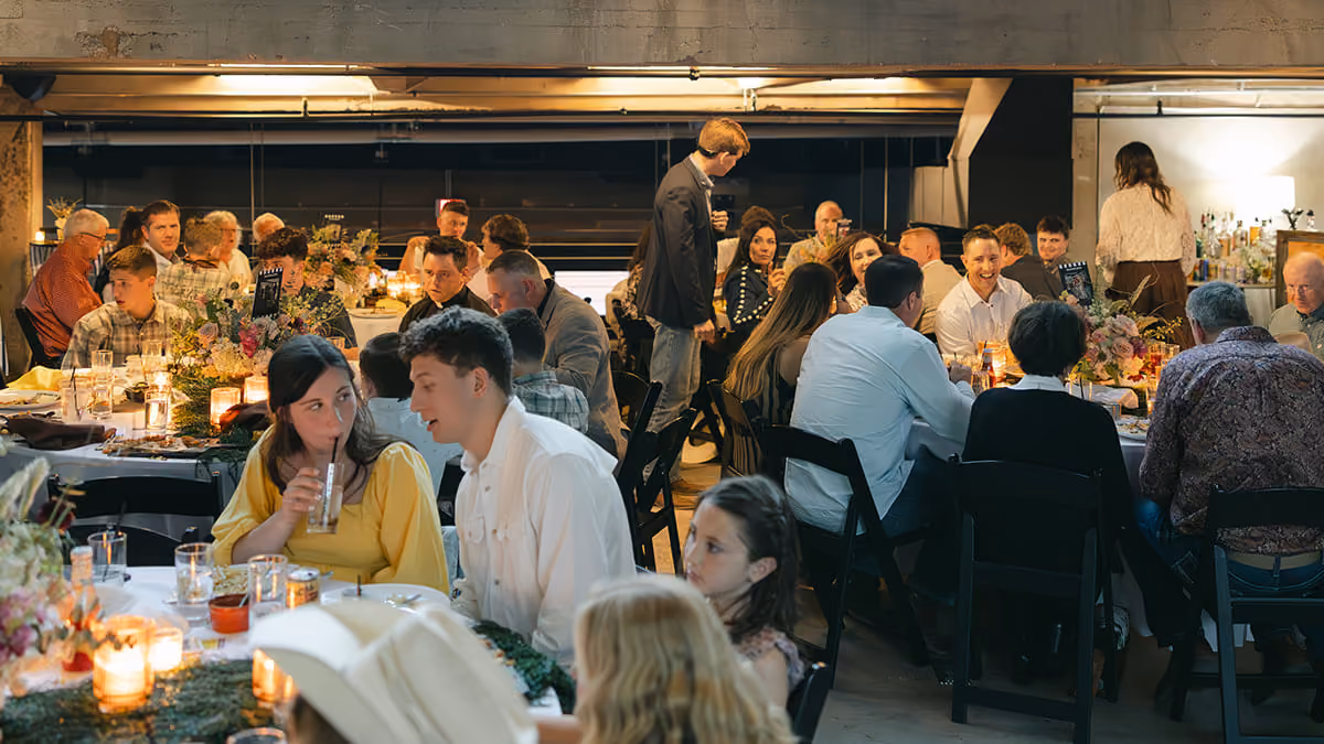Long banquet tables set beneath the mezzanine's tall factory windows