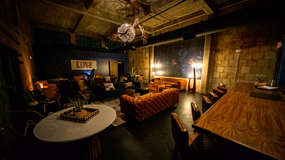 The Records Room at Tannahill's with tufted velvet sofas beneath a sculptural chandelier