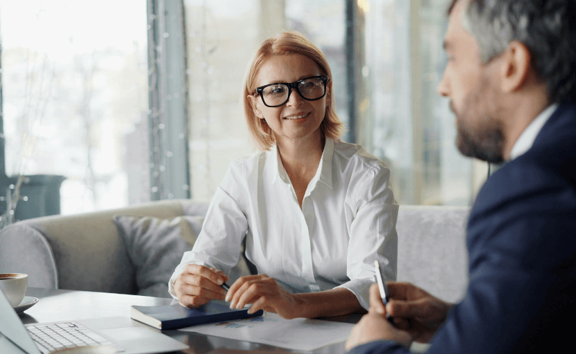 Woman with glasses in a meeting with a man in a suit