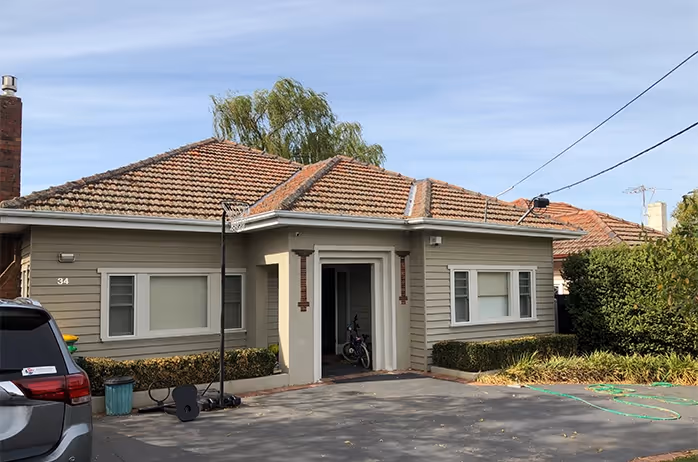 Single-storey brick house with tiled roof and front porch.