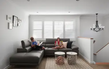 right living room in a home extension with children reading on a grey sectional sofa.