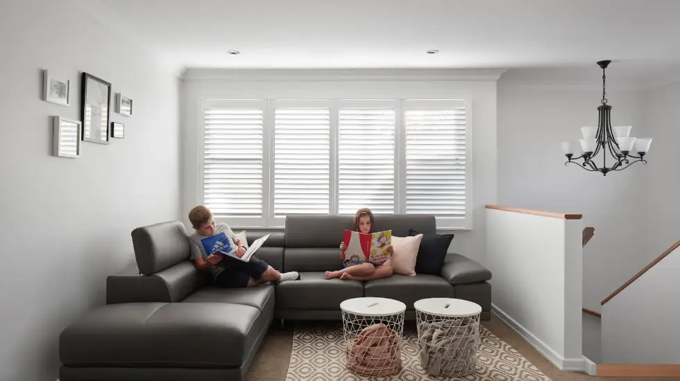 right living room in a home extension with children reading on a grey sectional sofa.