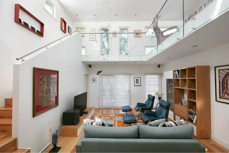 Modern double-height living room in a home extension with glass balustrade.