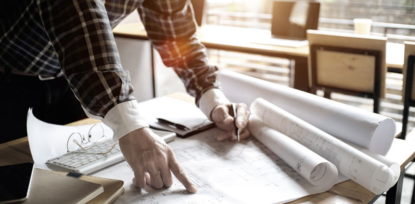 Designer reviewing house extension floor plans and drawings during the planning stage.