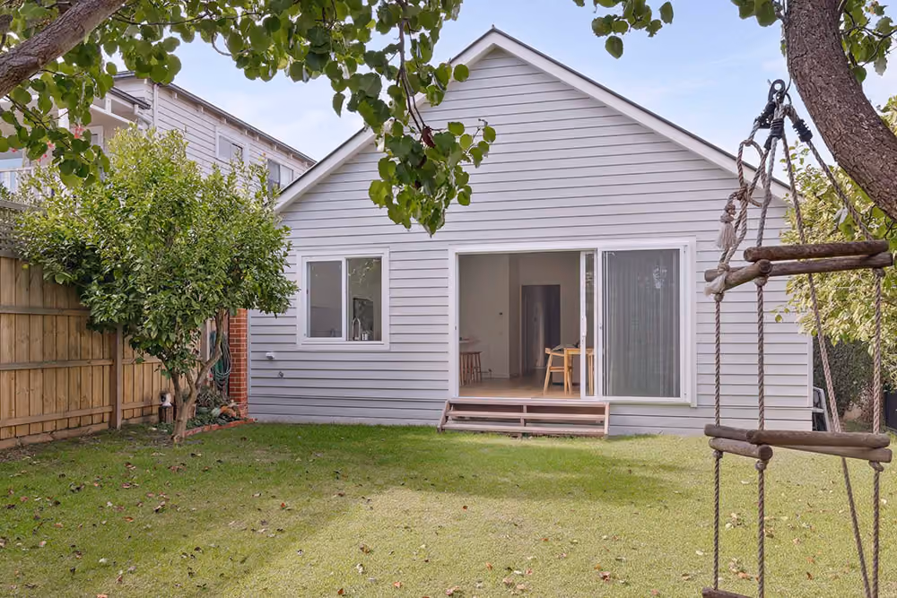 Rear view of a completed single-storey home extension opening onto a spacious backyard.