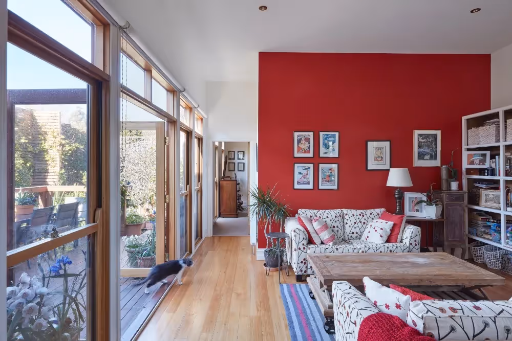 Spacious living area inside a completed home extension with large windows, timber flooring and garden views.