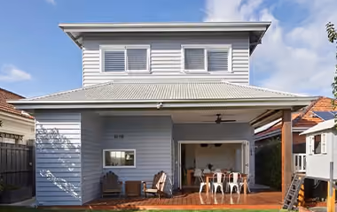 Rear view of a completed two-storey home extension with an outdoor entertaining area and covered deck.