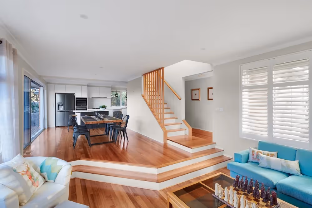 Open-plan living and dining area with a staircase connecting a ground-floor extension to the upper level.