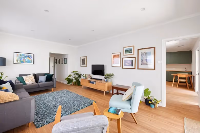 Bright open-plan living room created through a modern home extension with timber flooring.