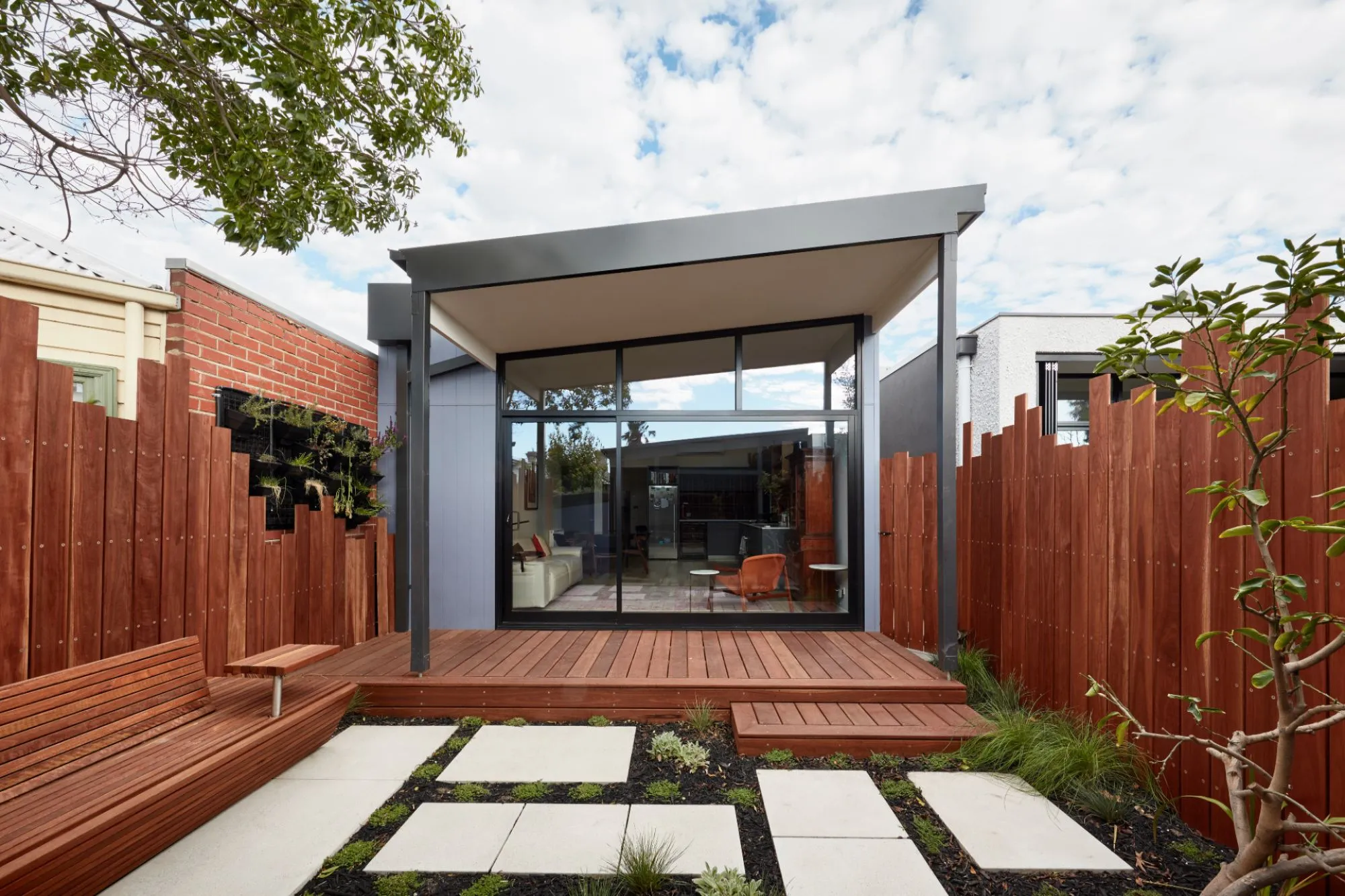 Built-in wooden shelving hallway with window seat and books.