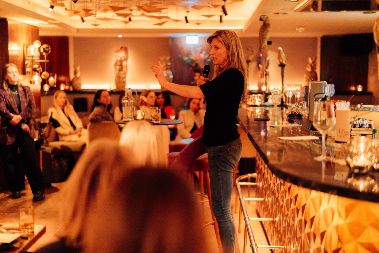 Maja Göpel steht in einer Bar und unterhält sich mit Gästen.