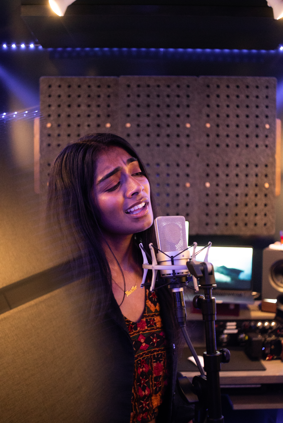 A talented LAAMP student passionately singing into a professional studio microphone, showcasing the vocal skill, confidence, and artistry of the program’s participants. The high-quality studio setting—with pristine acoustics, modern equipment, and ambient lighting—emphasizes LAAMP’s commitment to providing a world-class environment where students can fully express and refine their musical talents.