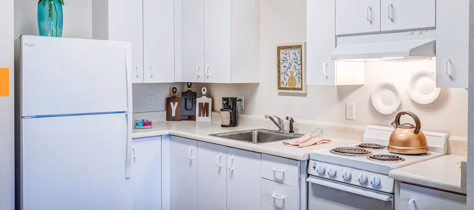 Granite Falls, WA Over 55 Communities - The Village at Granite Falls - Kitchen with White Appliances, White Cabinets, and Dual Sinks.