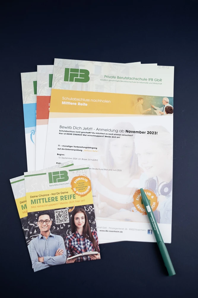 Eine Sammlung von Bildungsbroschüren der Privaten Berufsfachschule IFB ist auf einer dunklen Fläche angeordnet. Die Hauptbroschüre hebt „Mittlere Reife“ mit einem Foto zweier lächelnder Personen hervor. Daneben liegt ein grüner Stift. Der Ton ist informativ und einladend.