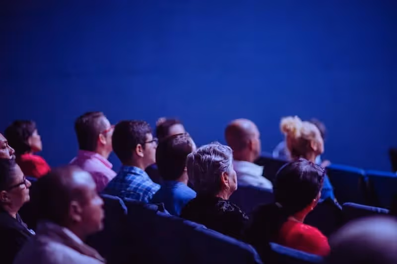 audience qui attend le début de la présentation dans une salle sombre