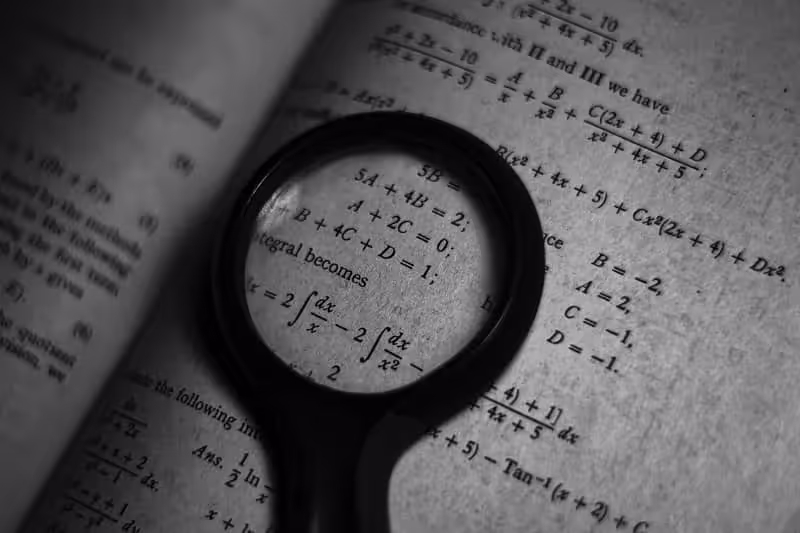loupe qui zoom sur un exercice de maths dans un manuel de mathématiques