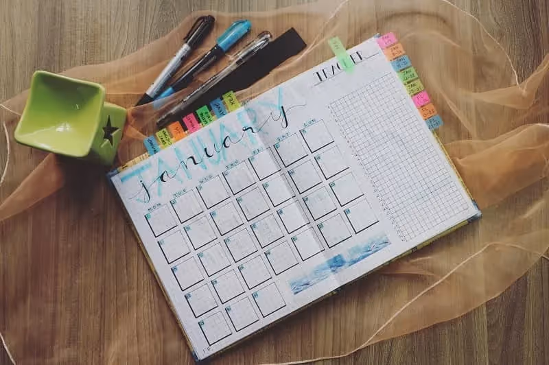 agenda carnet rempli de post it et ouvert à la page de janvier en anglais