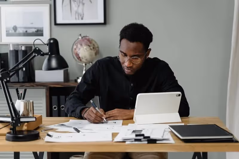 jeune homme qui travaille dans un bureau et qui est très concentré sur son travail